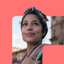 A Woman Techmaker, bag in hand, looks up with inspiration, framed by the WTM symbol of female coding power.